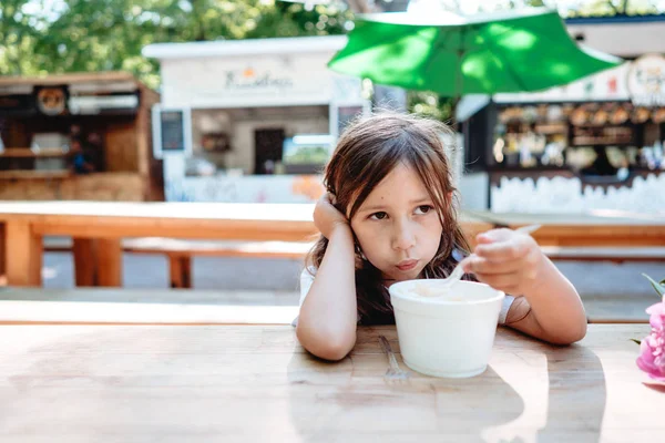 Menina comendo sorvete em um café — Fotografia de Stock