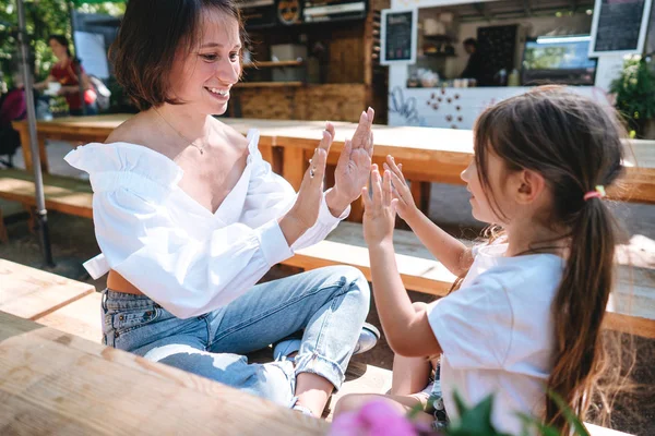 Madre e hija están sentadas en un café — Foto de Stock