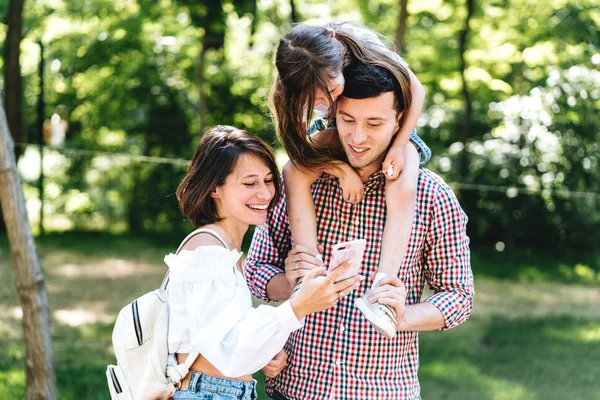 Anne baba ve küçük kızı bir smartphone vasıl arıyoruz — Stok fotoğraf