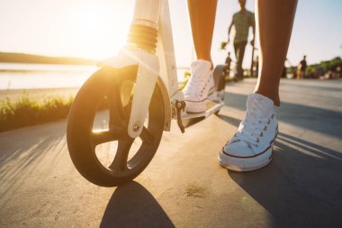 Kot pantolon ve spor ayakkabılar üzerinde bir tekme scooter görünümünün üst bacaklar