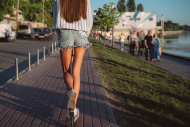 Güzel kız sokakta bir scooter sürme