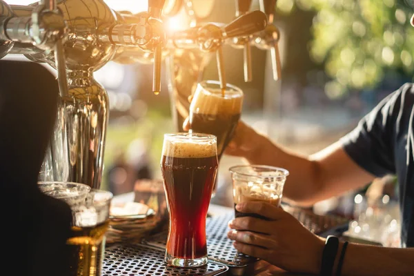 Barman giet een donker bier close-up — Stockfoto