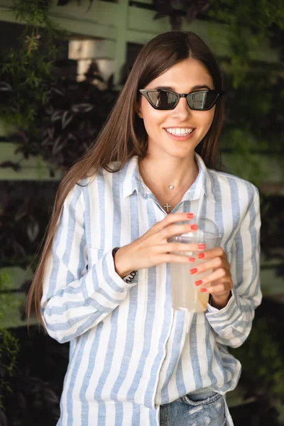 Beautiful young woman with plastic cup of fresh cocktail — Stock Photo, Image