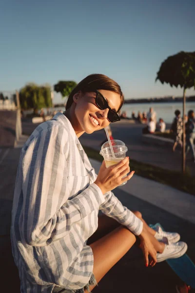 Молода дівчина в сонцезахисних окулярах зі склянкою лимонаду . — стокове фото