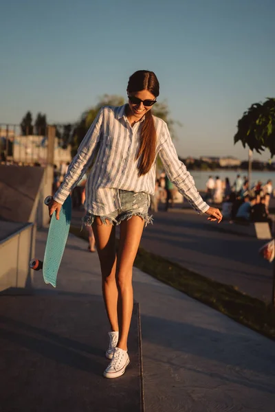 Красивая молодая девушка со скейтбордом в скейт-парке — стоковое фото