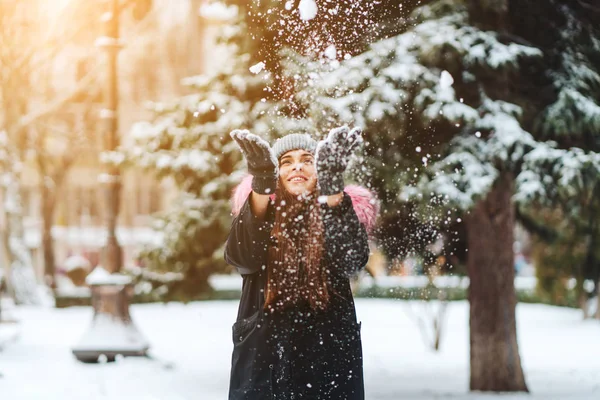 A menina joga neve na cidade . — Fotografia de Stock