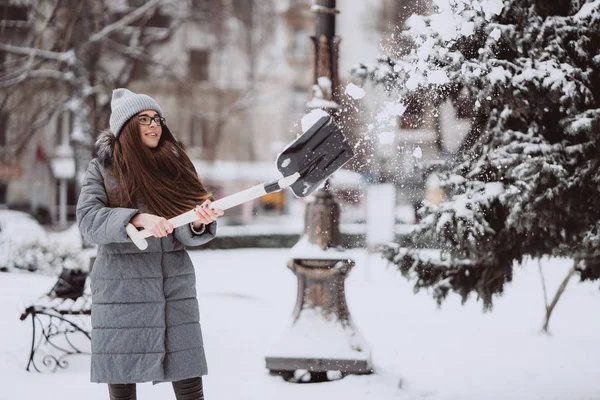 Menina bonita em roupas de moda de inverno com uma pá — Fotografia de Stock