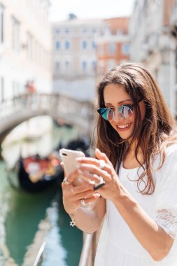 Genç kız Venedik sokaklarında fotoğraf makinesinde poz