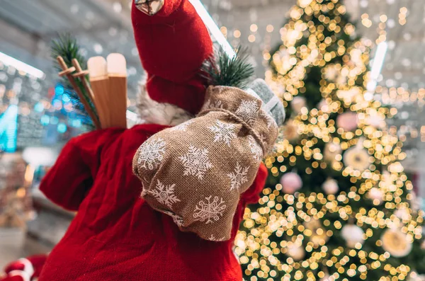 Санта ззаду з подарунковою сумкою на фоні ялинки боке . — стокове фото