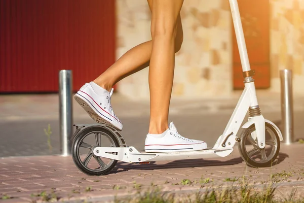 Mooi meisje rijden een scooter in de straat — Stockfoto