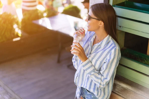 Красивая молодая женщина с пластиковой чашкой свежего коктейля — стоковое фото