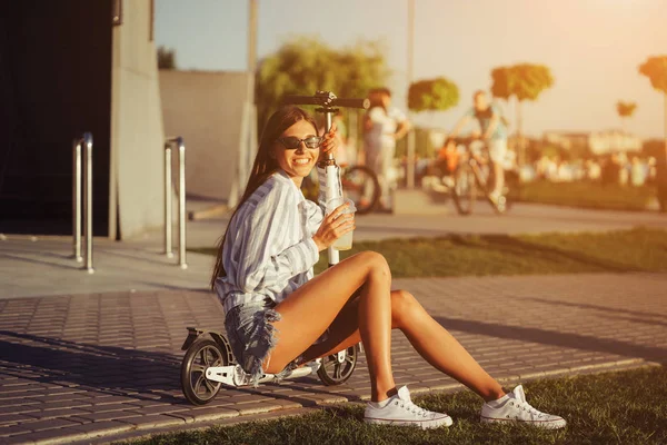 Menina bonita com scooter posando na câmera . — Fotografia de Stock