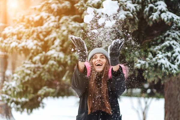 A menina joga neve na cidade . — Fotografia de Stock