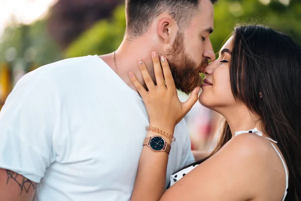 Handsome guy and beautiful girls kissing in the park — Stock Photo, Image