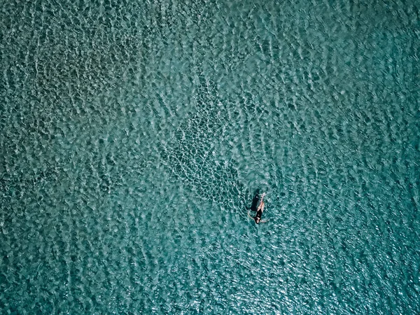 Молодая девушка в черном купальнике плавает в море . — стоковое фото