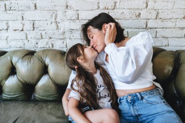 Annesi ve küçük kızı kanepede iyi eğlenceler.