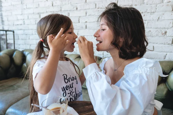 Chica con su madre come galletas de avena y divertirse — Foto de Stock