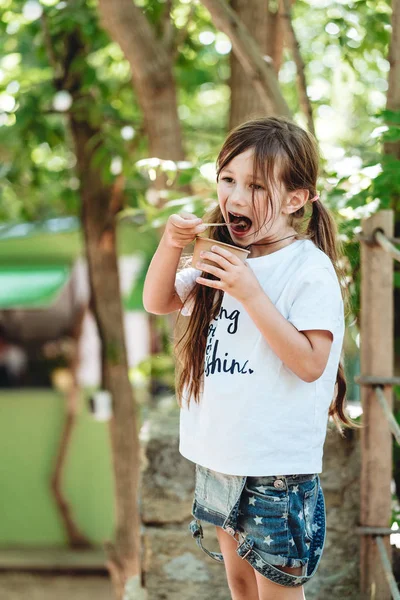 Egy kislány fagyit eszik a parkban. — Stock Fotó