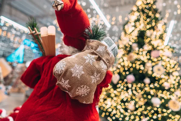 Papai Noel por trás com saco de presente no fundo da árvore de Natal bokeh . — Fotografia de Stock