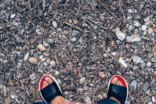 Mens feet on the background of stones and leaves — Stock Photo, Image