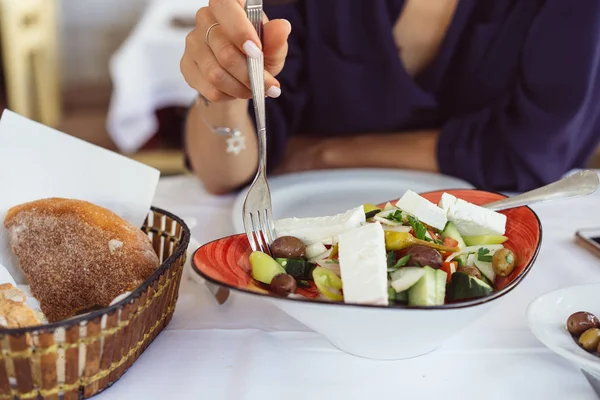 Χωριάτικη Σαλάτα, γυναικεία χέρια κρατούν ένα πιρούνι. — Φωτογραφία Αρχείου