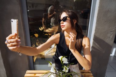 Beyaz buket ile oturan genç kadın.