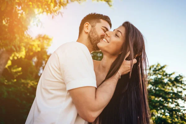 Pareja joven caminando y besándose en el parque de verano . —  Fotos de Stock