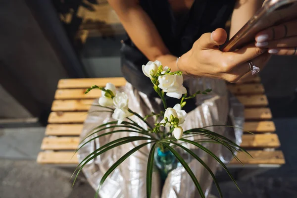 Mujer joven sentada con un ramo de flores blancas . — Foto de Stock