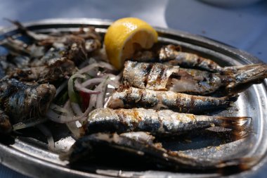 Kızarmış balık oval metal çanak üzerinde yatıyor.