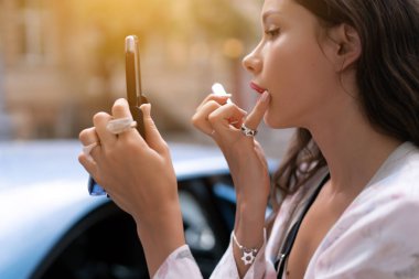 Kırmızı lipstic tutarak ve hızlı makyaj güzel kadın