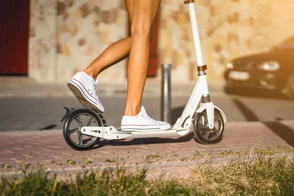 Mooi meisje rijden een scooter in de straat — Stockfoto