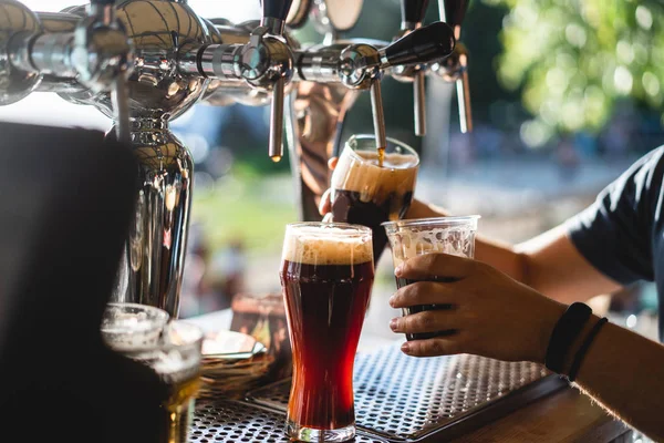 Barman giet een donker bier close-up — Stockfoto