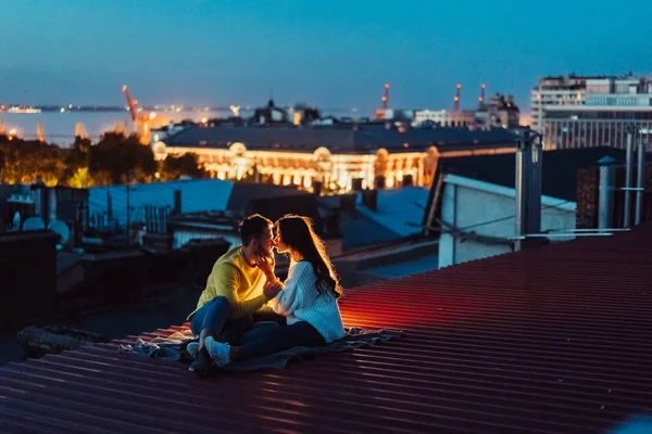 La pareja amorosa está sentada en el techo de la casa. Hermosa noche —  Fotos de Stock