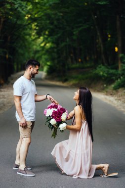 Kız bir buket peonies diz çöker .