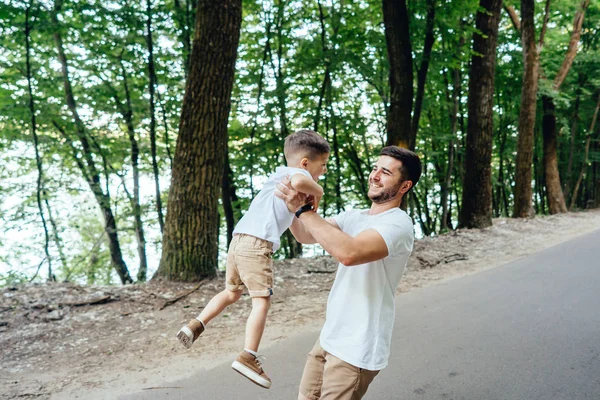 Felice padre sta girando tra le braccia del suo giovane figlio . — Foto Stock