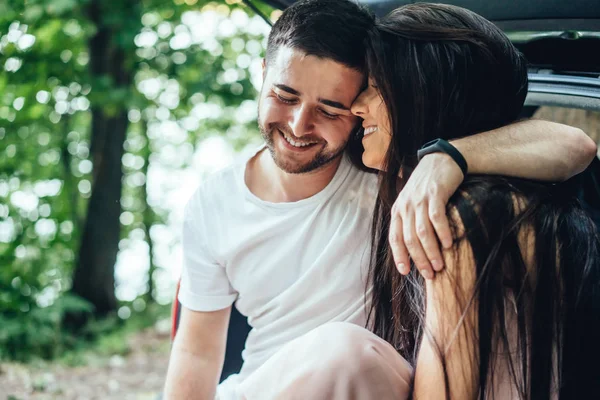 Couple is sitting in the trunk of their car. — Stock Photo, Image