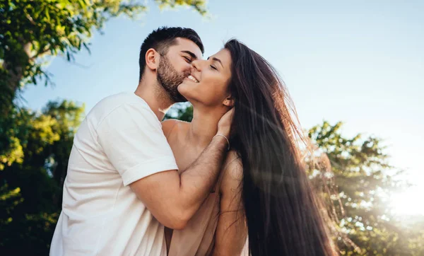Junges Paar spaziert und küsst sich im Sommerpark. — Stockfoto
