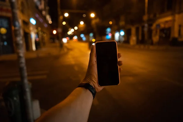 A mans bir akıllı telefon ile a siyah perde tutan el. — Stok fotoğraf