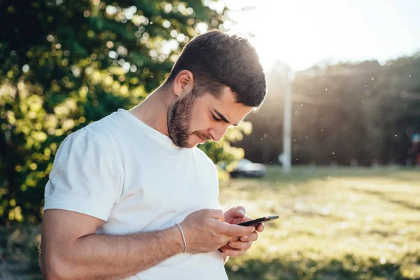 Jovem está lendo uma mensagem SMS . — Fotografia de Stock