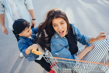 Küçük çocuk annesi bir sepeti kullanıyor.