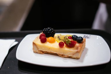 Masaya bir tabak peynirli kek ile olduğunu.