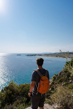 Adam uçurumun üzerinde duruyor. Genç bir adam seyahat.