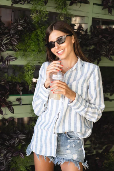 Beautiful young woman with plastic cup of fresh cocktail — Stock Photo, Image