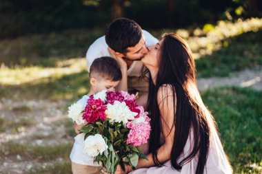 Genç aile yaz parkta dinleniyor.