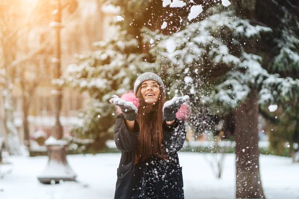 A menina joga neve na cidade . — Fotografia de Stock