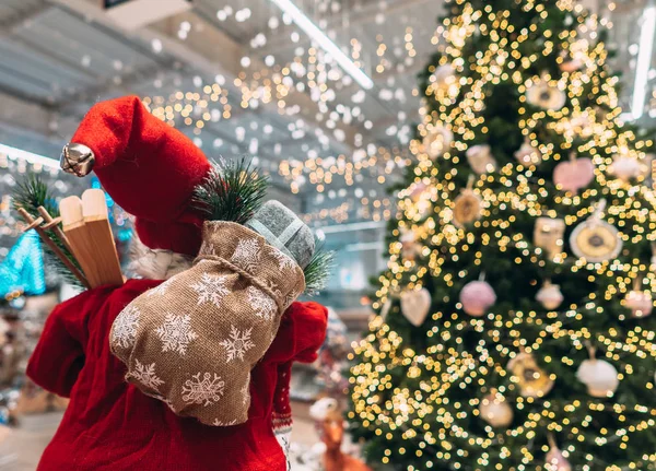 Санта ззаду з подарунковою сумкою на фоні ялинки боке . — стокове фото