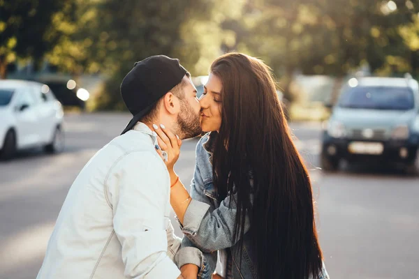 Jovens e amorosos pais se beijam no estacionamento perto do supermercado. — Fotografia de Stock