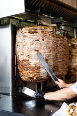 Dikey bir şiş üzerinden dilimleri kesme bıçağı, holding eller mans