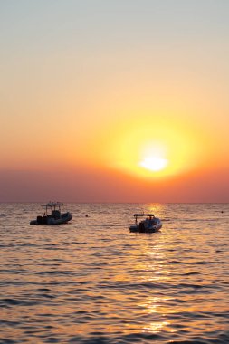 Güzel gün batımı. Mesafe iki küçük tekne görebilirsiniz.