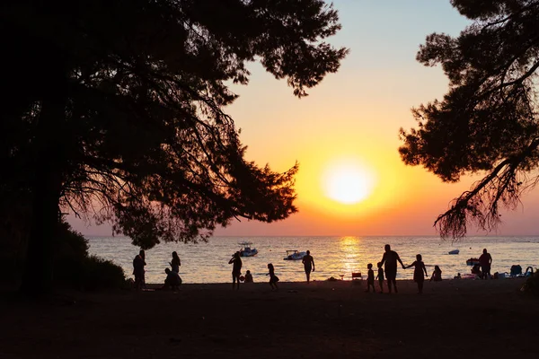 Op de avond strand mensen rusten. Zonsondergang. — Stockfoto